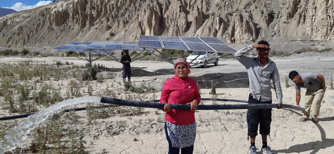 Customer holding a working solar pump pipe at a farm installation